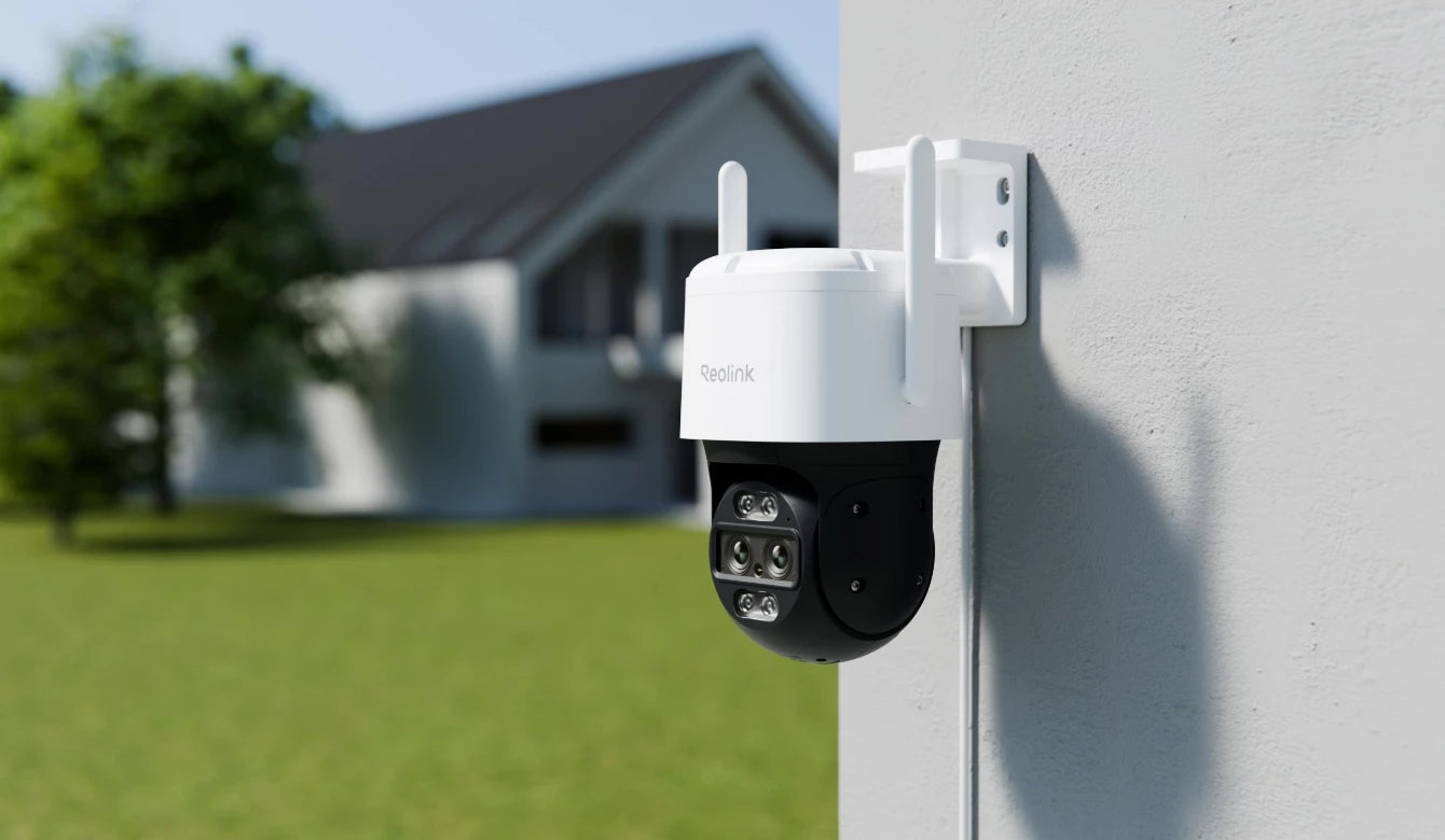 Reolink TrackMix WiFi an einer Außenwand über einem Garten
